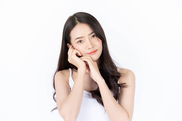 Jeune femme asiatique a le visage souriant et le ton de peau lumineux. Femme asiatique debout avec fond blanc isolé
. - Photo, image