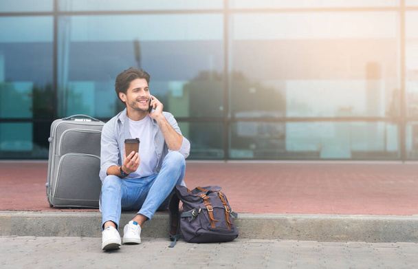 Muž mluví na mobilu a pití Nesu kávu mimo letiště - Fotografie, Obrázek