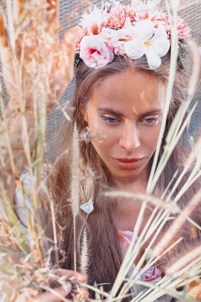 beautiful young woman wearing wreath with flowers outdoors portrait - Fotó, kép