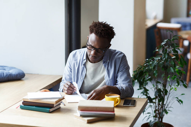Étudiant afro-américain travaillant dur sur la recherche dans la cantine universitaire
 - Photo, image