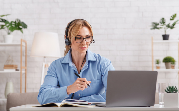 Online kuuleminen psykologi. Nainen lasit ja kuulokkeet tarkastellaan kannettava tietokone - Valokuva, kuva