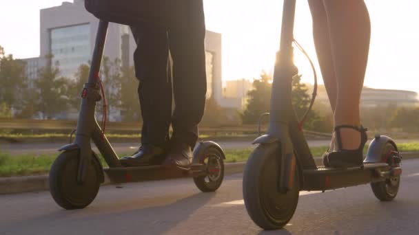 FLARE DE LA LENTE: Los rayos de sol dorados brillan en los compañeros de trabajo que montan scooters eléctricos para trabajar
 - Metraje, vídeo