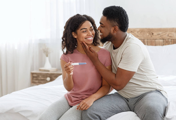 Happy husband cuddling wife, got positive pregnancy test - Foto, immagini