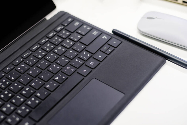 自宅のワークスペース上の黒いキーボードのラップトップペンとマウス、現代的なビジネスデジタル通信で自宅から仕事 - 写真・画像