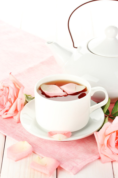 teapot and cup of tea with roses and on white wooden table - Foto, imagen