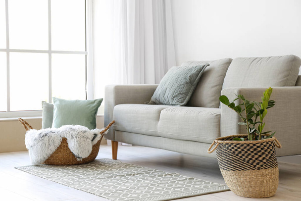 Плетені кошики біля дивана в кімнаті
 - Фото, зображення