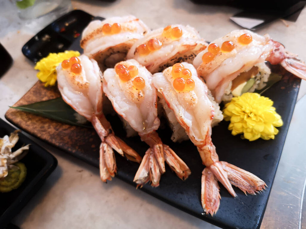 Сочная вкусная вкусная вкусная свежесть традиционной японской кухни сырые морепродукты сашими креветки установлен на темной тарелке в японском ресторане
 - Фото, изображение