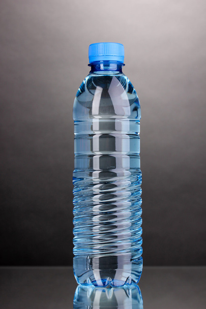 plastic bottle of water on grey background - Φωτογραφία, εικόνα