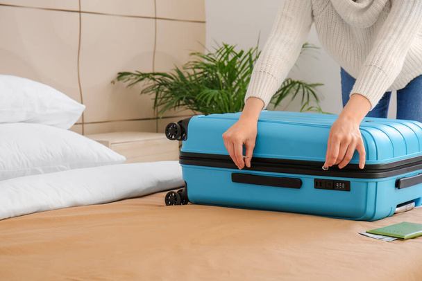 Young woman opening suitcase in hotel room - Photo, Image