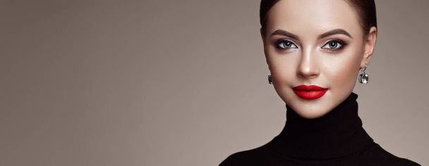 Beautiful Young Woman with Clean Fresh Skin. Perfect Makeup. Beauty Fashion. Red Lips. Cosmetic Eyeshadow. Smooth Hair. Girl in Black Turtleneck - 写真・画像