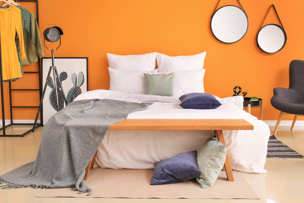 Elegante interior de la habitación con cama y banco
 - Foto, imagen