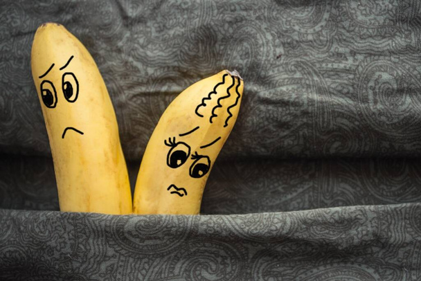 Im Bett, auf den dunklen Laken, zwei Bananen, ein Mann und eine Frau. Tiff, Groll, Groll Partner. Das Bild stammt vom Autor. - Foto, Bild
