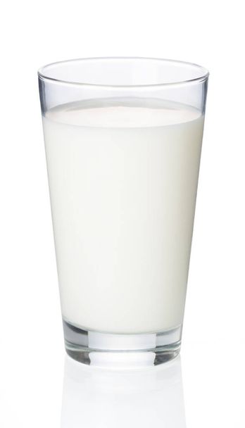 La leche en un vaso colocado sobre un fondo blanco es fotografiada desde un lado
. - Foto, imagen