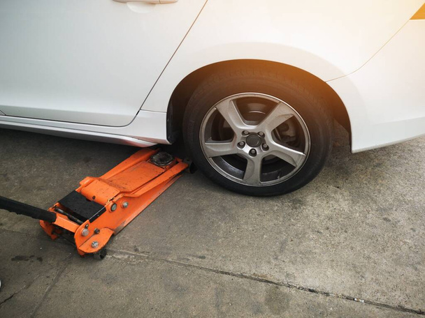 Aufbocken eines Autos mit dem Notheber zum Reifenwechsel. Auto reparieren. - Foto, Bild