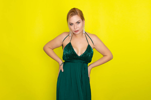 Fashion picture of beautiful young blonde woman wearing green evening dress. Elegant woman ready fo evening - Фото, зображення