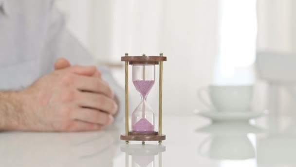 Hourglass on a Table next to Hands of a Man Waiting Impatiently - Footage, Video