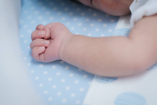 close-up Schattige kleine arm hand vingers huid van baby op het bed. - Foto, afbeelding