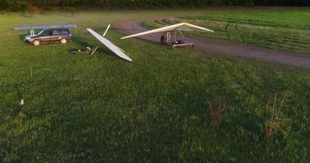 Drachenflug bei Sonnenuntergang über grünen und gelben Frühlingsfeldern. Luftaufnahme. Mit Drohne aufgenommen. - Filmmaterial, Video
