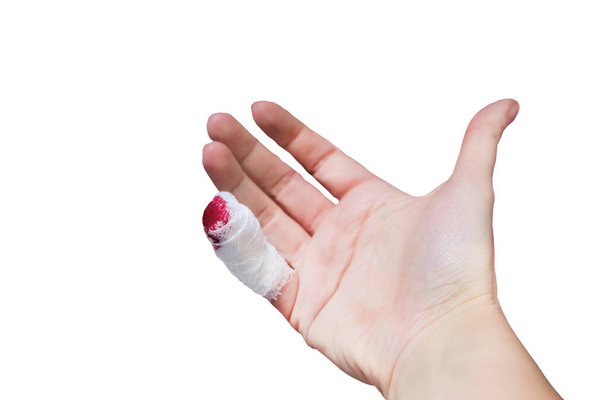 Close-up of a female hand with injured bleeding finger with bloody gauze on it. - Photo, Image