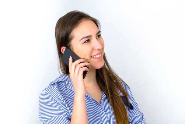 Attractive young woman smiling and talking on smartphone - Foto, Bild