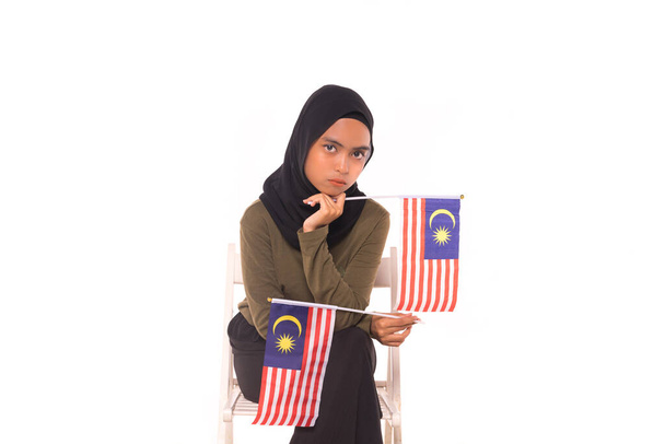 Malezya Bayrağını elinde tutan mutlu genç Malezyalı kız beyaz arka planda izole edildi. Bağımsızlık Günü konsepti. - Fotoğraf, Görsel
