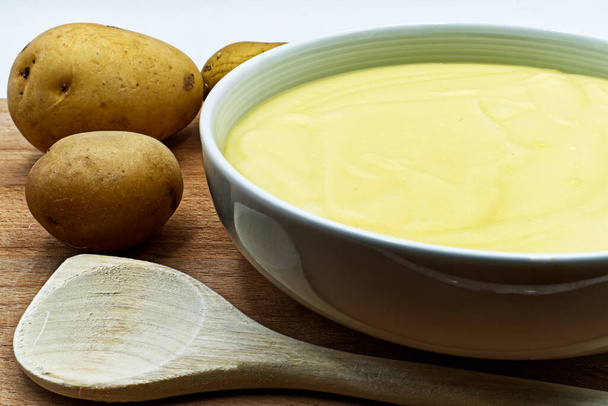 Bowl of mashed potatoes puree, with raw potatoes. Closeup - Photo, Image