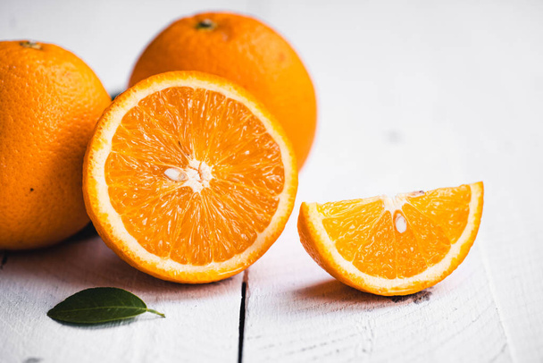 Appelsiinit valkoisella puupohjalla studiossa - Valokuva, kuva