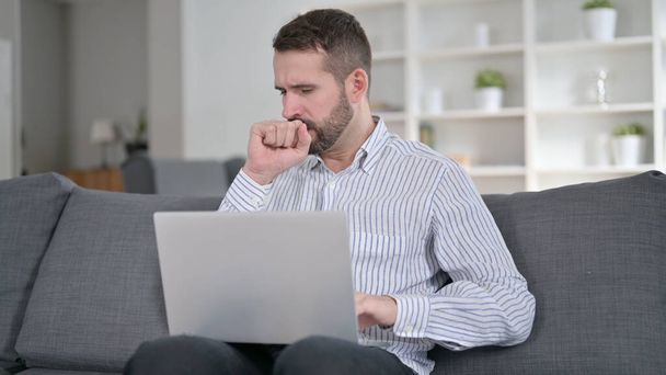 Sick Man Working on Laptop and Coughing at Home  - Photo, Image