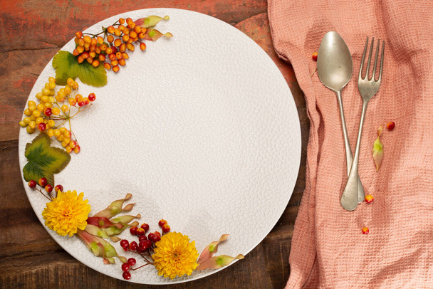 Stagionale colorato sfondo floreale autunno con fiori, bacche e pensione rotonda bianca, spazio copia, posto per il testo libero o menu ristorazione
 - Foto, immagini