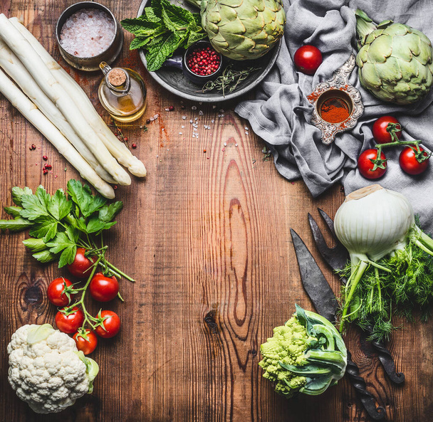 Vegetarian cooking concept with asparagus and Others organic harvest vegetables and ingredients on wooden rustic background, top view, frame - 写真・画像