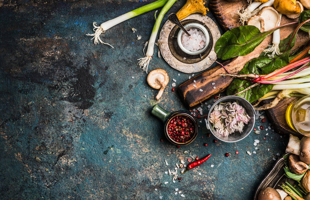 Fresh seasoning and vegetarian organic cooking ingredients for tasty cooking on dark rustic background, top view, place for text. Clean healthy organic vegan or vegetarian food concept - Photo, image