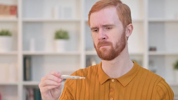 Sick Redhead Man Checking Temperature on Thermometer  - Foto, Imagen
