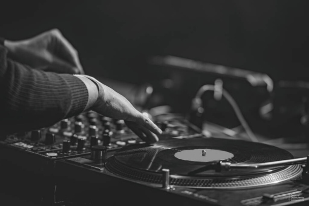 DJ 'in elleri pikap üzerinde kulüpte çalıyor. Disko. Gece hayatı. Atmosfer. siyah-beyaz fotoğraf. - Fotoğraf, Görsel