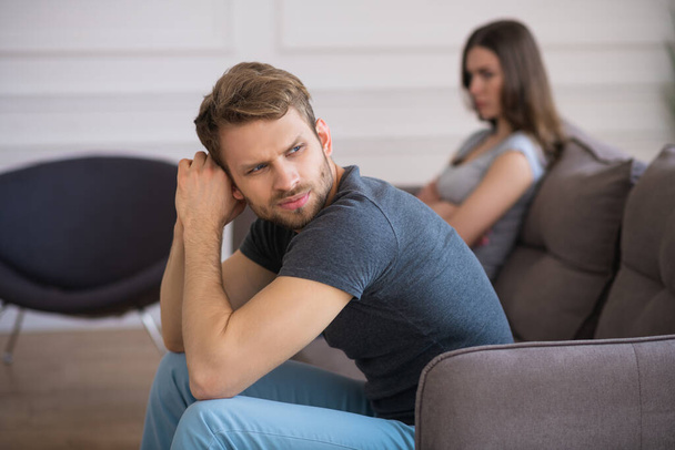 Young couple sitting on the sofa after a quarrel - Photo, Image