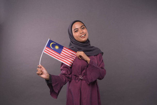 Malezya Bayrağı 'nı elinde tutan mutlu Malezyalı kız. Bağımsızlık Günü ve vatanseverlik konsepti. Stüdyo çekimi.. - Fotoğraf, Görsel