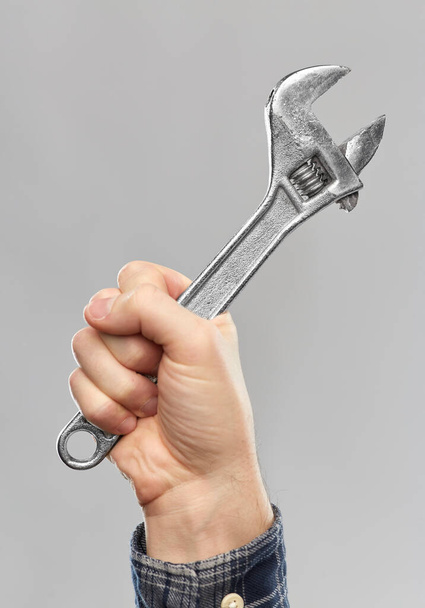 close up of builders hand holding wrench - Foto, Imagem