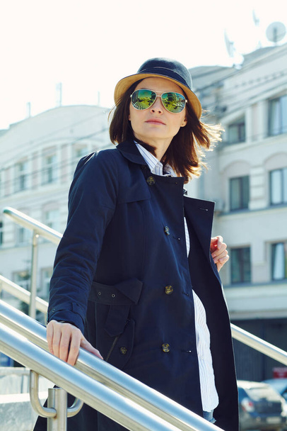 outdoor portrait of a stylish woman in a raincoat, hat and sunglasses. - Fotoğraf, Görsel