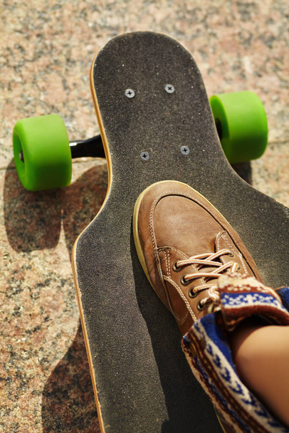 skater with a longboard closeup. trendy casual hipster person a skateboard. - 写真・画像