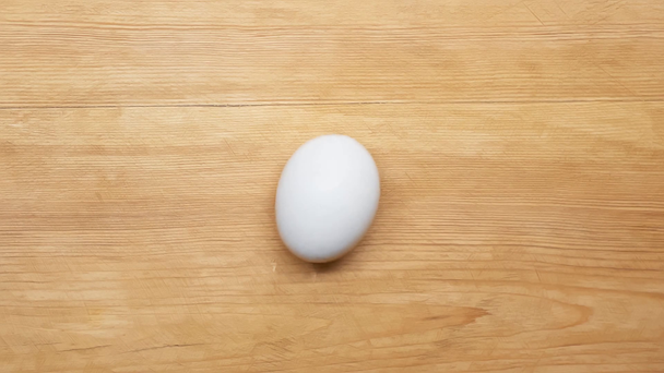Vista superior del huevo giratorio en la superficie de madera
 - Metraje, vídeo
