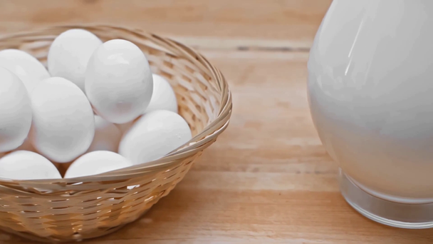 Uova in cesto di vimini e brocca di latte su superficie di legno
 - Filmati, video