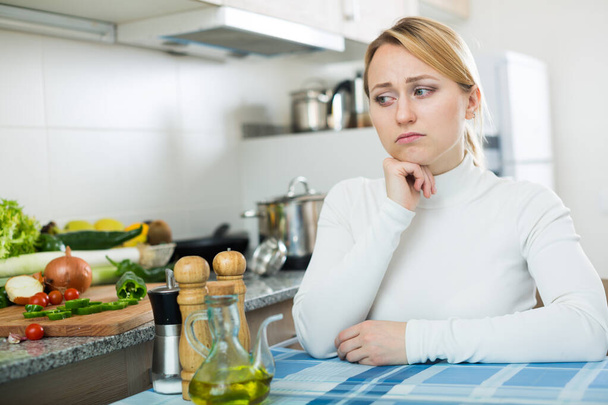 Retrato de una joven frustrada en la cocina doméstica - Foto, imagen