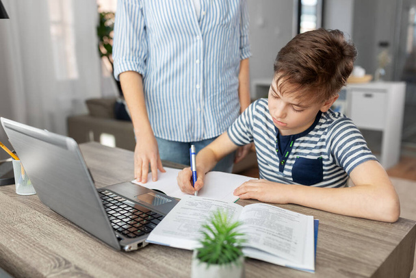 mother and son doing homework together - Фото, зображення