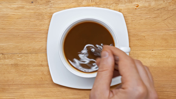 Vista superior do homem misturando café com colher na superfície de madeira
 - Filmagem, Vídeo