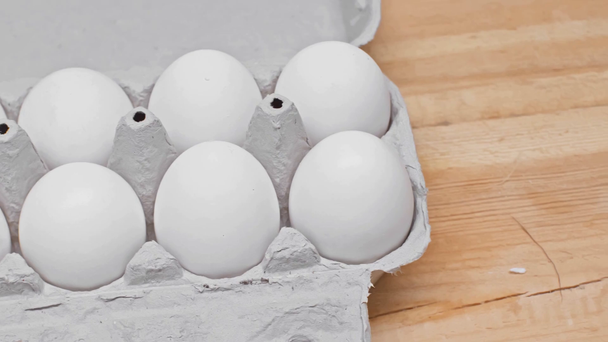 Uova in contenitore di cartone su superficie di legno
 - Filmati, video