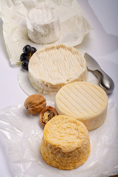Γαλλικό AOC μαλακά τυριά αγελάδας, τραγανά Langres με πλυμένη φλούδα, κοφτερή πίτα Angloys, καμαμπέρ με έντονη γεύση και μπρί σερβίρεται ως επιδόρπιο μετά το δείπνο - Φωτογραφία, εικόνα