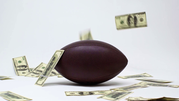 notas de dólar caindo perto de bola de rugby em branco, conceito de apostas online
  - Filmagem, Vídeo