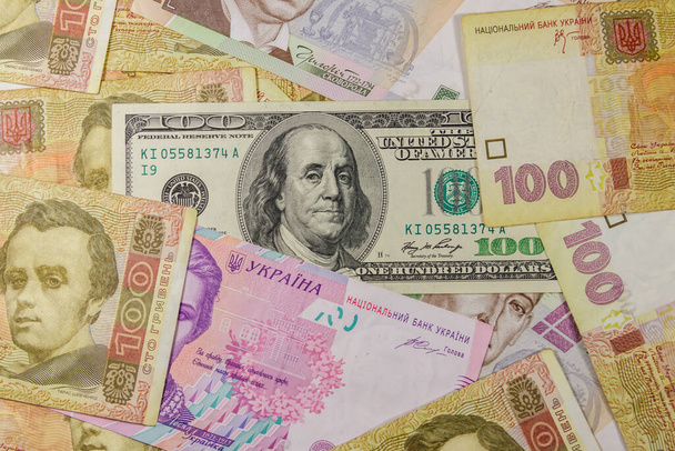 Billet de cent dollars sur fond de différents billets de banque en hryvnia ukrainienne - Photo, image
