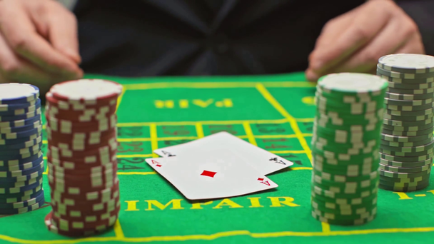 Zwolniony ruch gracza rzucającego karty w pobliżu żetonów pokerowych - Materiał filmowy, wideo