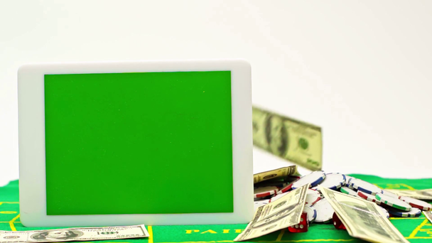 digitális tabletta zöld képernyővel közel eső pénz elszigetelt fehér - Felvétel, videó