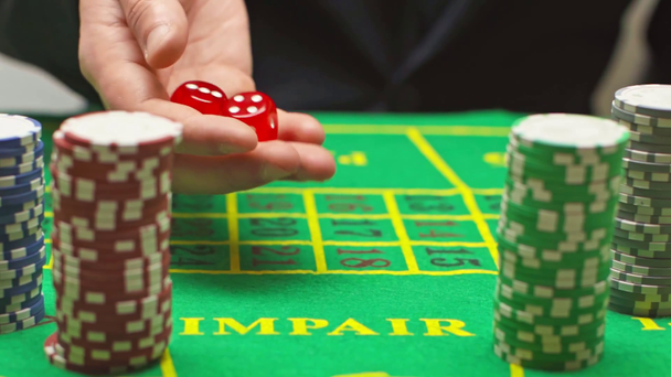 Langzame beweging van de speler dobbelstenen rollen in de buurt van poker chips  - Video